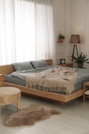 Téléchargez les photos : Chambre élégante avec lit double et belles plantes d'intérieur vertes. Intérieur moderne - en image libre de droit