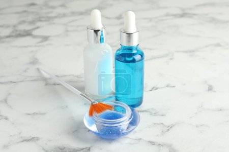 Chemikalienschälflaschen, Schüssel mit Flüssigkeit und Pinsel auf weißem Marmortisch. Peeling-Verfahren