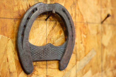 Horseshoe hang on the wall. Farm forge. Forged metal horse hoof guard