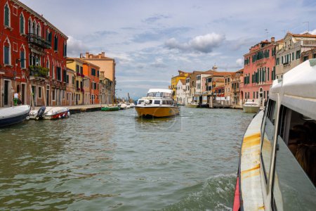 Photo for Venice, Italy - August 9, 2023; Perspective View of Venetian houses and boats along the canal - A fantastic travel destination - Royalty Free Image