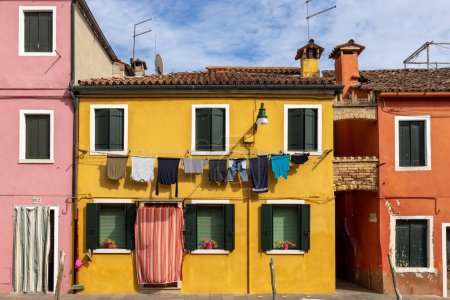 Téléchargez les photos : Burano, Italie - 9 août 2023 ; Détail de la blanchisserie suspendue, maisons vénitiennes colorées sur les îles Burano à Venise - une destination de voyage fantastique - en image libre de droit