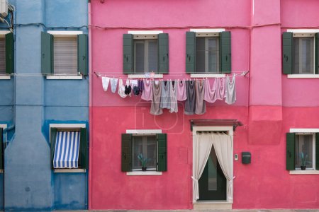 Photo for Burano, Italy - August 9, 2023; Detail of hanging laundry, colorful Venetian houses on the Burano Islands in Venice - a fantastic travel destination - Royalty Free Image