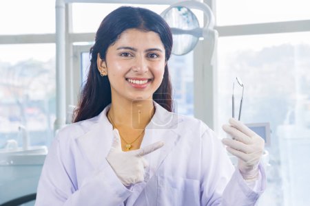 Téléchargez les photos : Belle indienne regarder népalais dentiste docteur fille sourire et donner des gestes - en image libre de droit