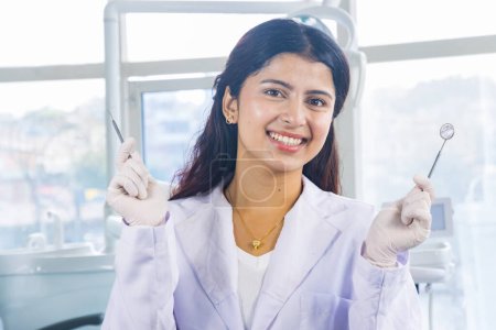 Téléchargez les photos : Belle indienne regarder népalais dentiste docteur fille sourire et donner des gestes - en image libre de droit