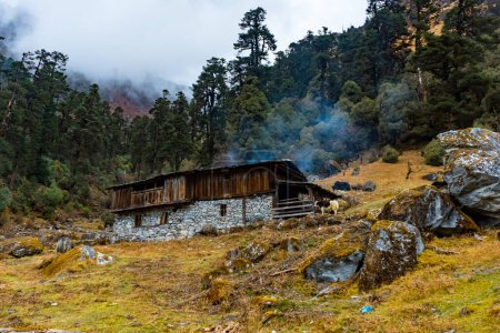 A typical Nepalese Himalayan Home made with wood and smoke coming out of hut in Taplejung, Nepal