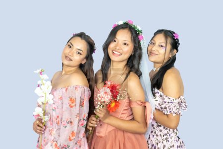 Schöne indische nepalesische Brautjungfer und Braut mit Blumen, die sich umarmen und der Brautdusche Ausdruck verleihen