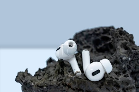 Paire d'écouteurs placés dans une maquette de podium en pierre volcanique 3D