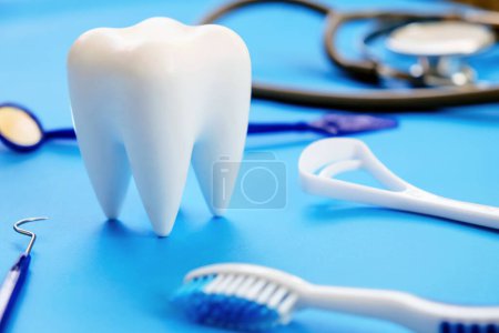 Dentalmodell und zahnärztliche Ausrüstung auf blauem Hintergrund, Konzeptbild des zahnärztlichen Hintergrunds. Hintergrund zur Zahnhygiene