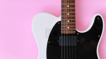 Téléchargez les photos : Guitare électrique noire et blanche sur fond rose. Vue du dessus. - en image libre de droit