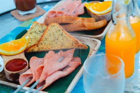 Téléchargez les photos : Petit déjeuner avec pain, jambon, fromage, jus d'orange et jus de fruits - en image libre de droit