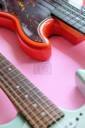 Foto de Guitarra eléctrica y bajo eléctrico sobre un fondo rosa con espacio de copia. - Imagen libre de derechos