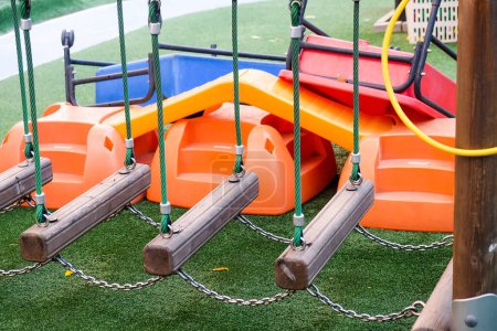 Deserted playground with various equipment and toys on green synthetic grass