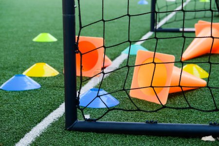Téléchargez les photos : Objectif de football et cônes sur gazon artificiel vert, fond de sport. - en image libre de droit