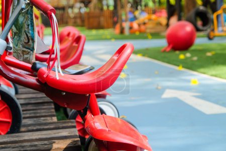 Parque infantil en parque público, primer plano de sillas rojas.