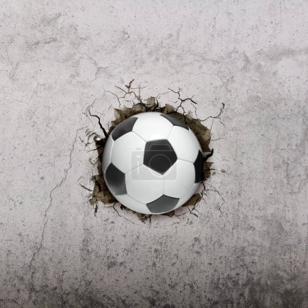 Téléchargez les photos : Ballon de football volant à travers le mur avec des fissures - en image libre de droit