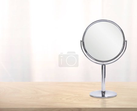 Round mirror on wooden table