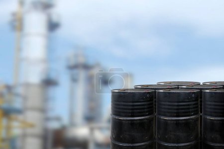 Black oil barrels against with Oil refinery blurred background