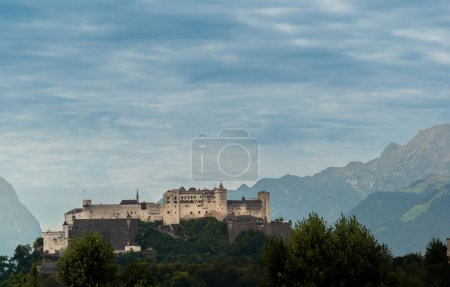 Salzburg, Austria, August 15, 2022. The fort dominates the city from the top of the hill, mountains in the background.