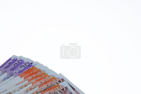 Photo for .A plan view close up spread of ten and twenty pound notes sterling isolated on a white background - Royalty Free Image