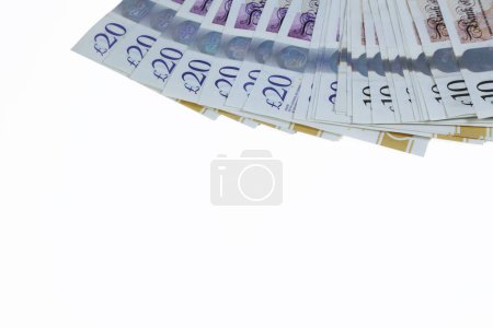 Photo for A plan view of spread of ten and twenty pound notes sterling isolated on a white background. - Royalty Free Image