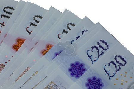 Foto de A plan view close up spread of ten and twenty pound notes sterling isolated on a white background. - Imagen libre de derechos