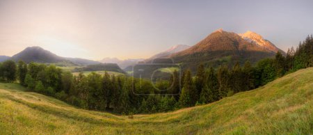 Meadow with road and bench near Hintersee lake during sunset in Berchtesgaden National Park, Upper Bavarian Alps, Germany, Europe. Clipping path of sky
