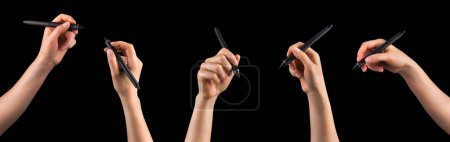 Hand holding digital graphic pen and drawing something isolated on black background with clipping path