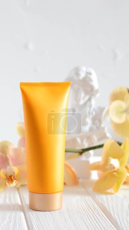 Photo for Mockup cream tube, yellow blank bottle and orchid flower, place for text - Royalty Free Image