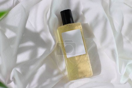 Foto de Botellas cosméticas burlón en la cama con sombras, ambiente matutino - Imagen libre de derechos
