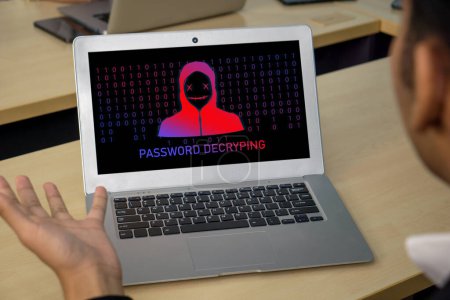 Foto de Un hombre está observando atentamente la pantalla de su computadora portátil que muestra la palabra PASSWORD DECRYPING, - Imagen libre de derechos