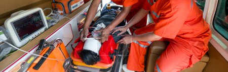 Eine Person trägt eine Sauerstoffmaske und holt sich Hilfe von Sanitätern in orangefarbener Uniform im Krankenwagen.
