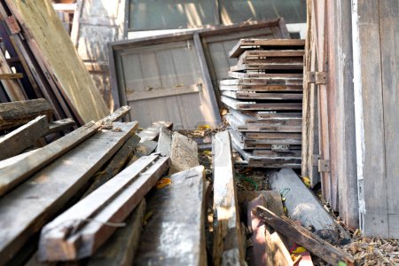 Old wooden plank, window and door are scattered in a disorganized pile.