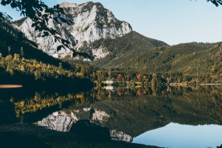 Majestic Austrian Alps lake reflecting autumn beauty in nature.