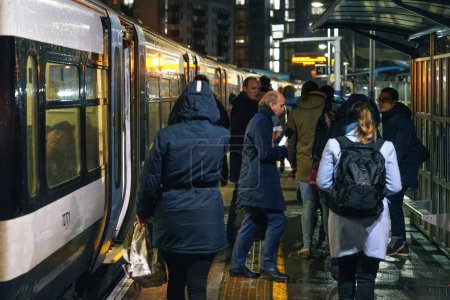 Téléchargez les photos : Londres, Royaume-Uni - 01 février 2019 : Les passagers descendent du train national sur le quai de la gare de Lewisham pendant la soirée froide et pluvieuse - en image libre de droit