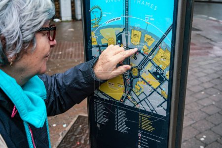 Téléchargez les photos : Londres, Royaume-Uni - 04 février 2019 : Une femme âgée pointe du doigt le Southbank Centre sur une carte de Londres, alors qu'elle planifie son voyage - en image libre de droit