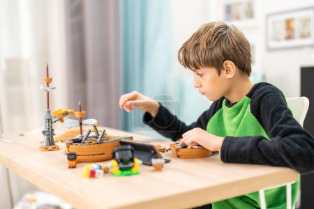 Photo for Cute boy playing alone at kindergarten with construction toy - Royalty Free Image