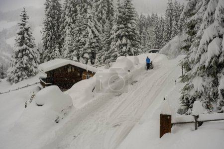 Téléchargez les photos : Homme utilisant chasse-neige, montagnes enneigées en arrière-plan, heure d'hiver - en image libre de droit