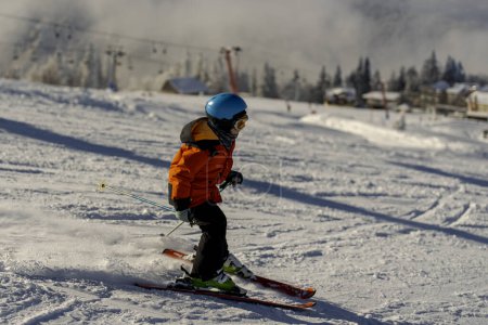 Téléchargez les photos : Boy enjoying ski on slope in the mountains, sunny day, wintertime - en image libre de droit