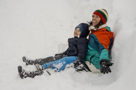 Foto de Madre e hijo jugando y disfrutando de la primera nieve - Imagen libre de derechos
