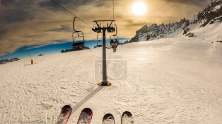 Photo for Friends on chair lift in a ski resort around Sela mountain, Selaronda, Dolomites, Italy - Royalty Free Image