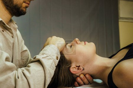 Photo for A CST treatment session for a woman, Osteopathic Manipulation and CranioSacral Therapy. Non-traditional medicine. Health care - Royalty Free Image