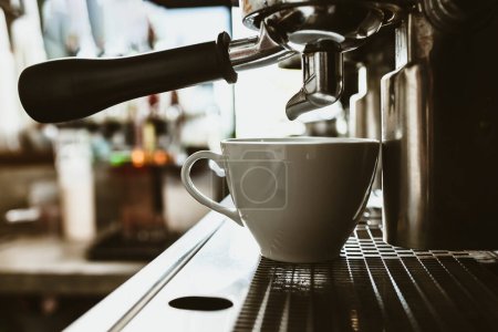 Téléchargez les photos : Machine à expresso dans le comptoir du café offrant du café fraîchement infusé. concept de cafetière. - en image libre de droit