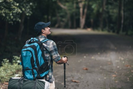 Téléchargez les photos : Les randonneurs utilisent un bâton de trekking avec des sacs à dos sur la route dans la forêt. concept de randonnée et d'aventure. - en image libre de droit