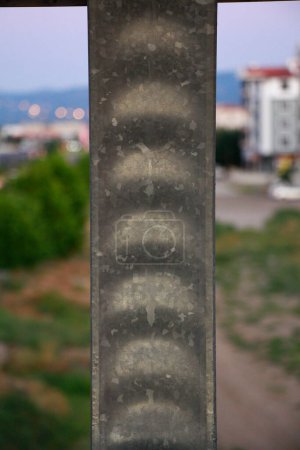 Un disparo vertical de una columna de soporte de metal con una vista de la ciudad en el fondo.
