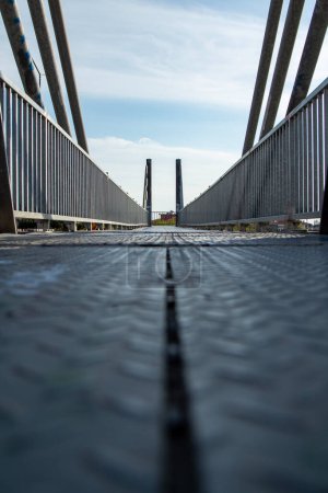 Foto de Puente peatonal sobre la carretera sobre un fondo de cielo azul. Vista de cerca de la estructura de acero de un puente moderno. - Imagen libre de derechos