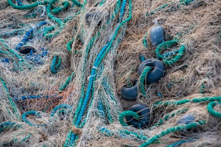 Fishing nets on the pier in the evening light. Fishing nets and ropes on the beach. Fishing nets and ropes on a fishing boat, closeup of photo