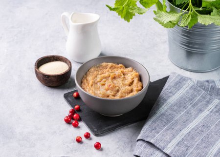 Téléchargez les photos : Porridge de semoule aux baies rouges dans un bol sur fond bleu avec du lait. Le concept d'un délicieux, nutritif et sain petit déjeuner. Alimentation et énergie alimentaire. - en image libre de droit