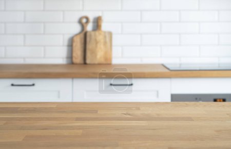 Photo for Wooden oak countertop with free space for mounting a product or layout against the background of a blurred white kitchen. Copy space - Royalty Free Image