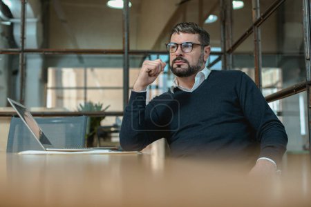 Téléchargez les photos : Male entrepreneur sitting at his workplace and thinking about a new project - en image libre de droit