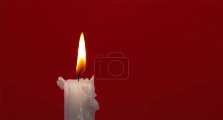 Foto de Imagen de tamaño de banner de vela encendida sobre un fondo rojo con espacio de copia gratuito para texto - Imagen libre de derechos